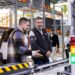 Men observe automated conveyor belt system in warehouse